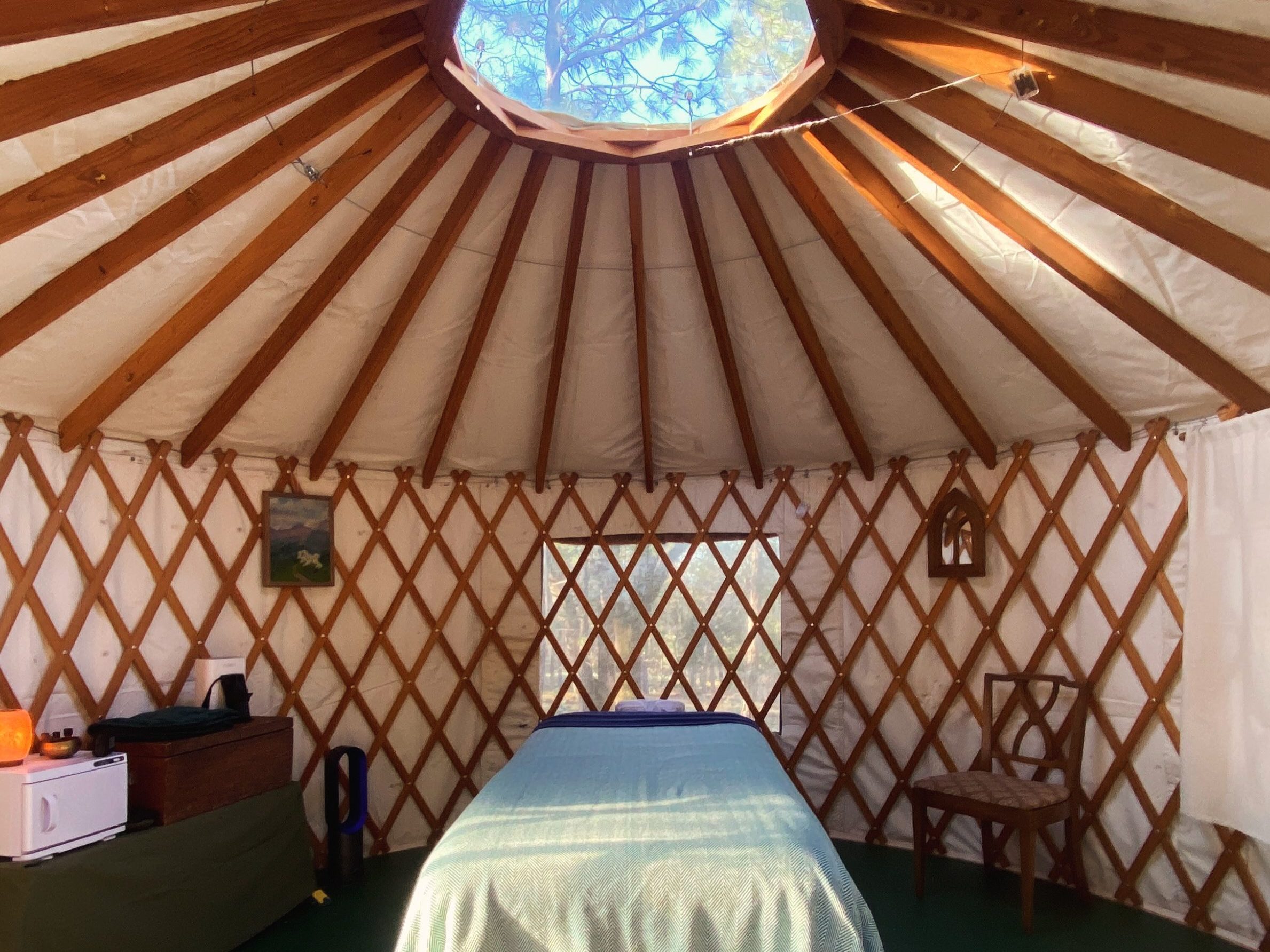 Interior of a yurt showing a massage table. Beautiful space for relaxing massage. Theraputic massage in the North State, near Redding California.